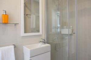 a white bathroom with a sink and a shower at Fashionable and Modern Apartment - Cascais in Cascais