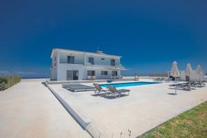 a villa with a swimming pool in front of a house at Villa Marylou in Protaras