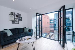 Hilltop Serviced Apartments - Piccadilly في مانشستر: غرفة معيشة مع أريكة وطاولة