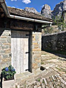 a door in a stone building with a stone wall at Κονάκι in Papigko