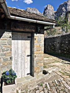 una porta in un edificio in pietra con un muro di pietra di Konaki Hotel a Papigko