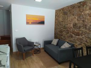 a living room with a couch and a chair at Dúplex Costa de Fisterra I in Finisterre