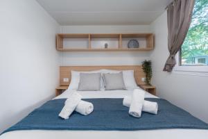 ein Schlafzimmer mit einem großen Bett mit zwei Kissen in der Unterkunft Mobile Homes Banko in Bijela Uvala and Zelena laguna in Poreč