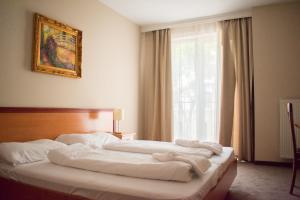 A bed or beds in a room at P4W Hotel Residence Szombathely