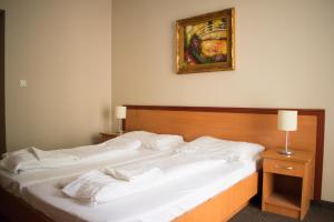 A bed or beds in a room at P4W Hotel Residence Szombathely