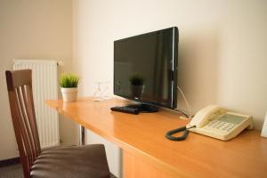 A television and/or entertainment centre at P4W Hotel Residence Szombathely