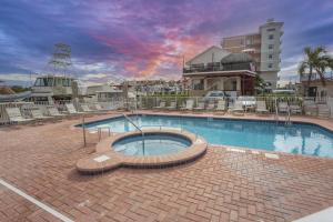 a large swimming pool in a brick walkway next to a building at Madeira Bay Heated Pool 204 Star5Vacations in St Pete Beach