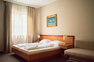 A bed or beds in a room at P4W Hotel Residence Szombathely