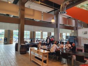 a group of people sitting at tables in a restaurant at Arena Assens in Assens