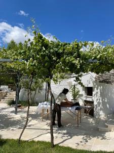a man is standing next to a tree at Trullo Matilde in Martina Franca