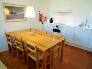 a kitchen with a wooden table and some chairs at Fine Arts Convento das Bernardas BB in Tavira