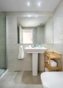 ein Badezimmer mit einem weißen Waschbecken und einem Spiegel in der Unterkunft Casa Lobo Panticosa in Panticosa