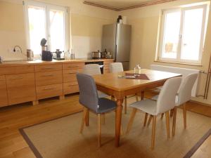 a kitchen with a wooden table and chairs at Ferienwohnungen Im grünen Eck in Airlenbach +20 photos