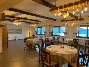 jadalnia ze stołami, krzesłami i oknami w obiekcie Hotel Valkarana Country Relais w mieście Sant Antonio Di Gallura