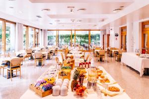 una grande stanza con tavoli con sopra del cibo di Albergo Sorriso a Boario Terme