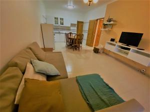 ein Wohnzimmer mit einem Sofa und einem TV in der Unterkunft NS GuestHouse in Armação de Pêra