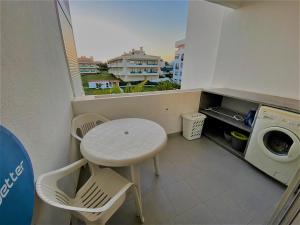 a small balcony with a table and a washing machine at NS GuestHouse in Armação de Pêra