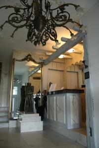 a large mirror in a room with a chandelier at Hotel Ambassade in Waregem