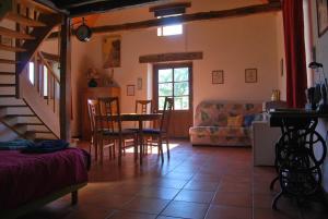 a kitchen and living room with a table and chairs at Le Chant du Coq in Lacave