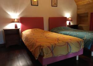 two beds in a room with two lamps at Le Chant du Coq in Lacave