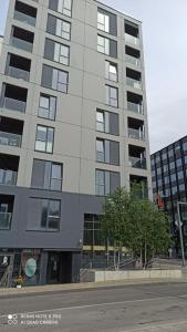 a tall gray building with a tree in front of it at Urban center apartment in Vilnius