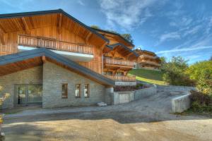 a house with a wooden facade with a balcony at Bailicîmes Apartment - Snow and Trek - Morzine in Morzine