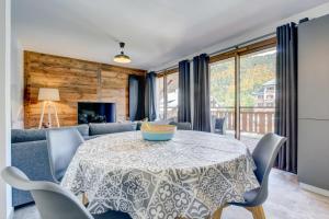 a dining room with a table and a couch at Bailicîmes Apartment - Snow and Trek - Morzine in Morzine