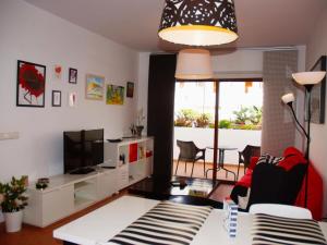 a living room with a couch and a tv at La Tunera in Costa Teguise