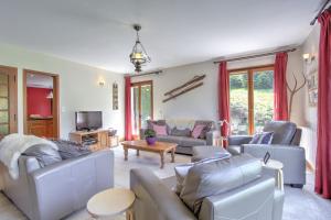 a living room with couches and a tv at Pont Aux Filles - Snow and Trek in Morzine