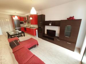 Ámbar في بلايا هوندا: غرفة معيشة مع أريكة حمراء ومطبخ