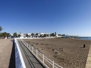 a beach with a fence and a bird on the sand at Ámbar in Playa Honda