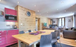 a kitchen and living room with a wooden table and a dining room at Beziere - Snow and Trek in Morzine