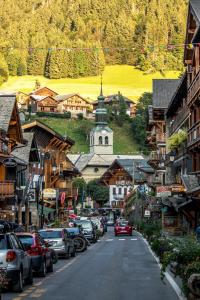 una calle con coches estacionados en el lado de una montaña en Nant Crue Apartment - Snow and Trek - Morzine, en Morzine