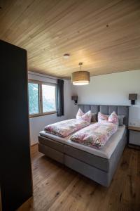 a bedroom with a large bed with pink pillows at Panoramahof Bergglück in Mellau