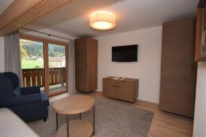 a living room with a couch and a table and a television at Apartment Brandstätter 1 & 2 by Apartment Managers in Brixen im Thale