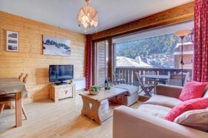 a living room with a couch and a tv at Le Slalom - Very Town Centre - Snow and Trek in Morzine