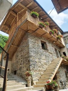 a stone building with stairs and potted plants on it at Chalet MariBru in Pradleves