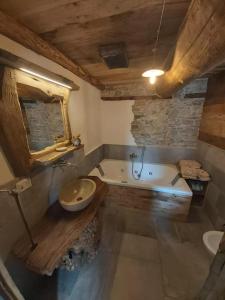 La salle de bains est pourvue d'une baignoire, de toilettes et d'un lavabo. dans l'établissement Chalet MariBru, à Pradleve