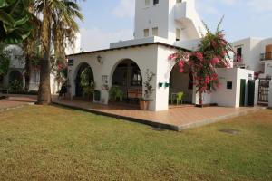 a white building with a courtyard with flowers at Apartamentos Torrelaguna in Vera