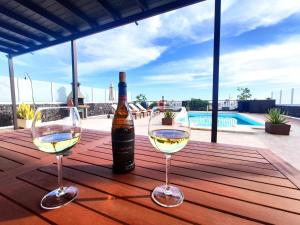dos copas de vino blanco sentadas en una mesa de madera en Villa 21, en Puerto del Carmen