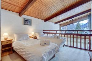 Duas camas num quarto com varanda em Le Pleney em Morzine