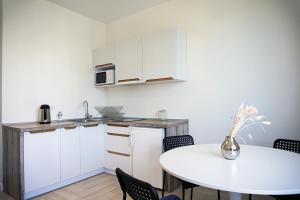 a kitchen with a table and a white counter top at Arkadia apt in Odesa