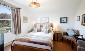 アンブルサイドにあるEasedale Lodgeのベッドルーム1室(ベッド1台、窓、椅子付)