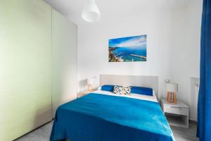 a bedroom with a blue bed with a blue blanket at Dreamers' House Sorrento in Sorrento
