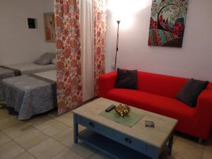 Sala de estar con sofá rojo y mesa de centro en Casa Zoe, en Puerto del Carmen