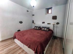 una camera con un letto con una coperta rossa di Roca redonda a Haría