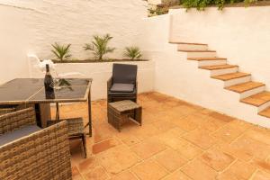 a patio with a table and chairs and stairs at Langleigh Villa in Ilfracombe