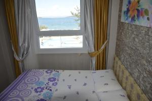 een slaapkamer met een bed en een raam met uitzicht bij Ege Apart & Hotel in Ayvalık