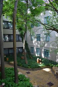 a building with trees in front of it at Zsolnay Negyed Vendégháza in Pécs