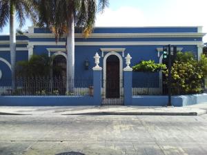 una casa azul con una puerta y palmeras en Künük Hotel Boutique en Mérida